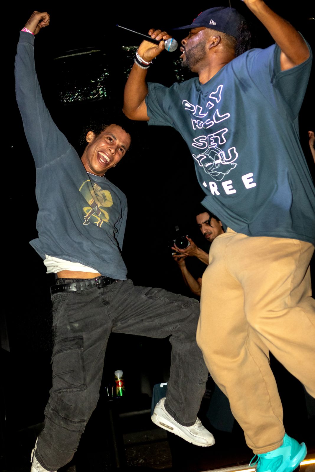 Ryan and a fan jumping mid-song, both with arms up