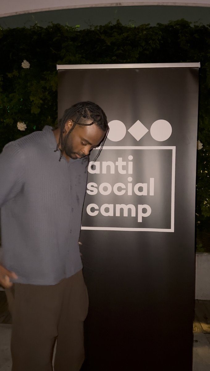Ryan beside the Anti-Social Camp banner